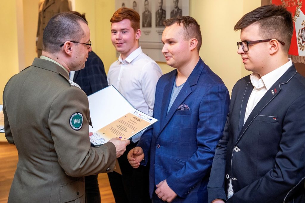 Rektor-Komendant WAT, gen. bryg. prof. dr hab. inż. Przemysław Wachulak wręczający nagrodę panu Kamilowi Koniakowi, zdobywcy (wraz zespołem) II miejsca w konkursie”