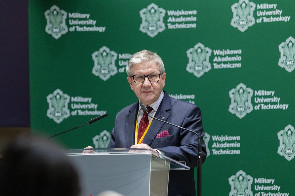 Kierownik Centrum wiedzy o dostępności, doktor habilitowany inżynier Jerzy Jackowski, profesor WAT podczas wystąpienia dotyczącego osiągnięć uzyskanych w ramach realizowanego projektu, w tle ścianka z logotypem WAT