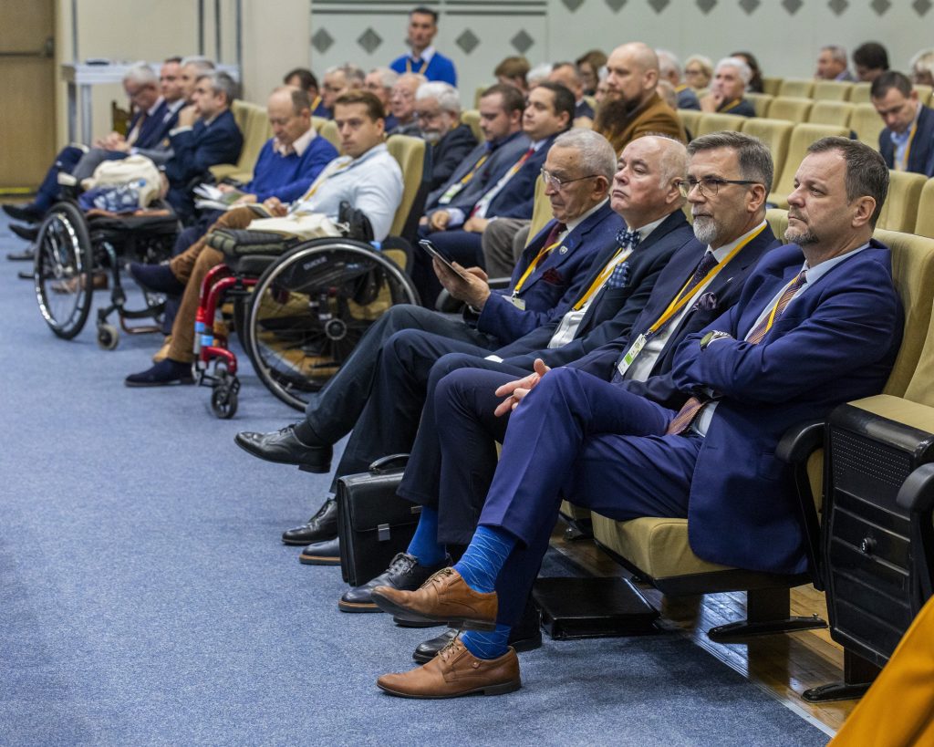 Uczestnicy konferencji siedzący w Auli Klubu WAT, słuchający wystąpień w ramach jednej z sesji plenarnych, na pierwszym planie od lewej generał Stanisław Świtalski, pan Walerian Żyndula, profesor doktor habilitowany inżynier Lucjan Śnieżek, doktor habilitowany inżynier Witold Luty, prof. PIMOT